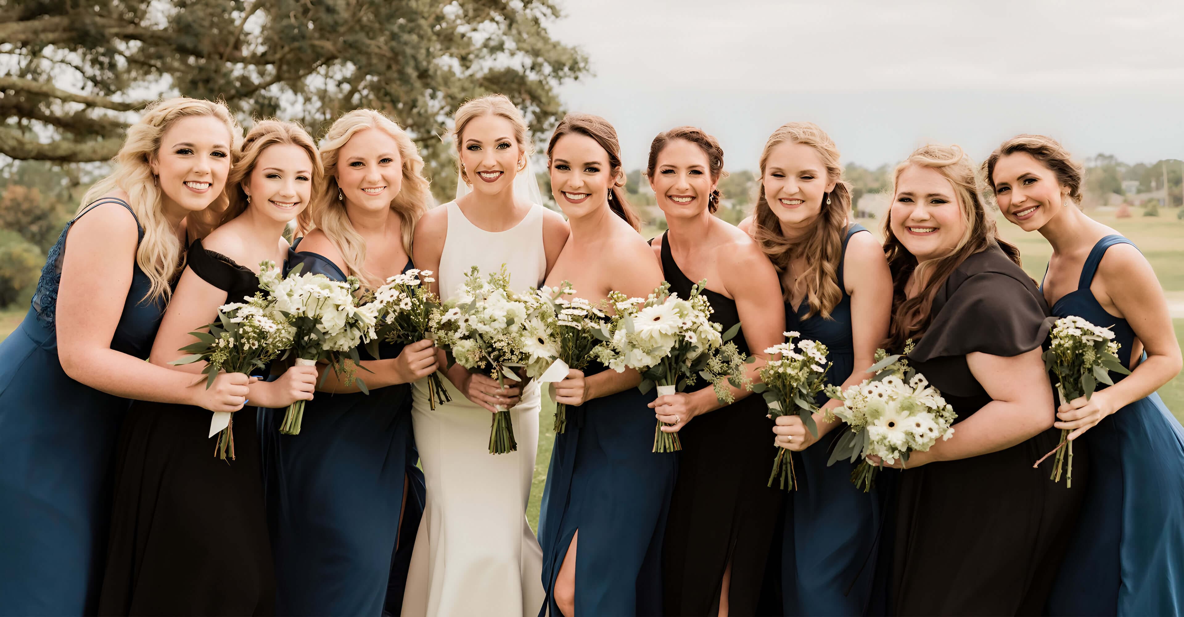 A group of women holding flowers posing for a picture.