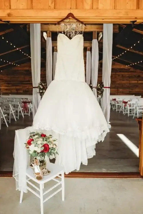 A wedding dress hanging in the middle of an indoor ceremony.