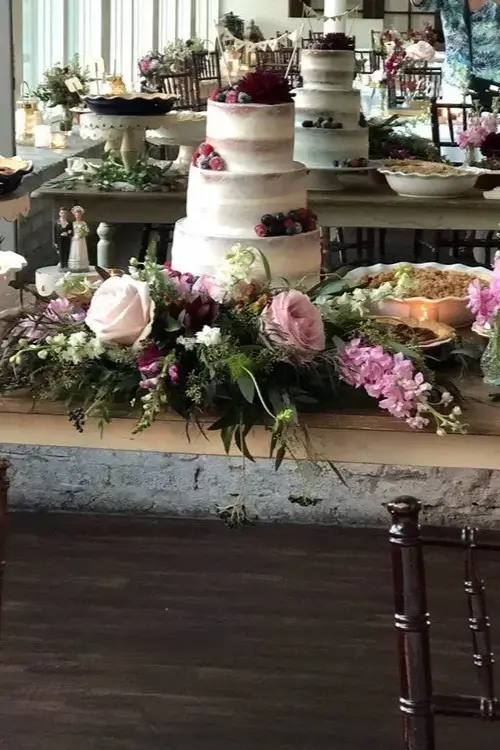 A table with flowers and cakes on it