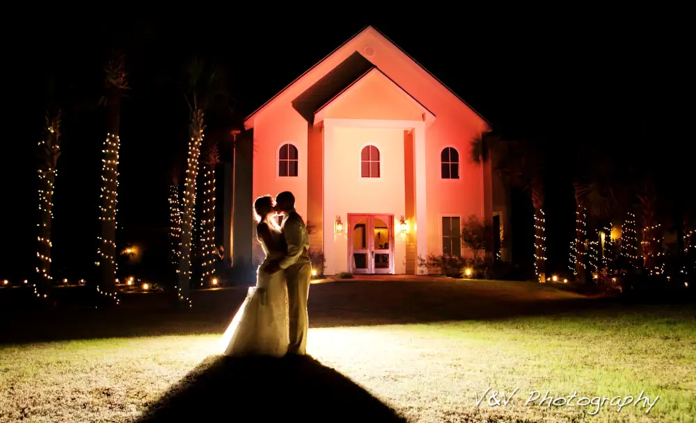 A couple is standing in front of a church at night.